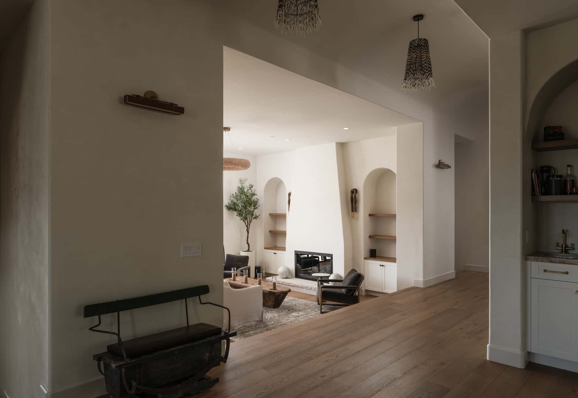 A plaster living room, afternoon light across the wall.